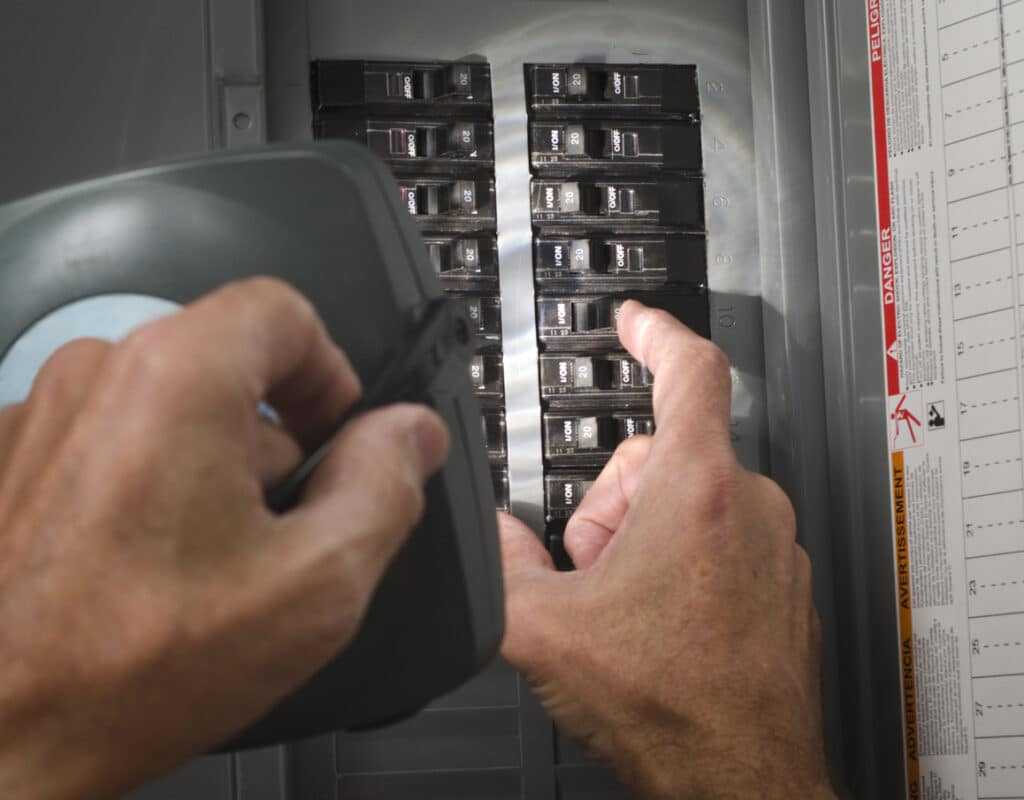 man throwing circuit breaker at residential service panel